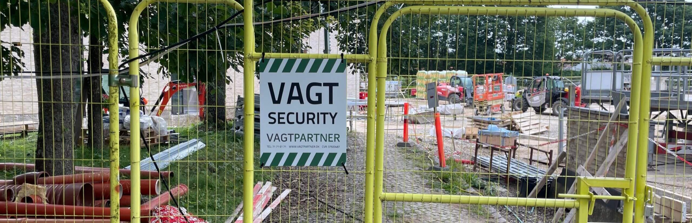 Sikret byggeplads med Vagtpartner-skilt på adgangshegn