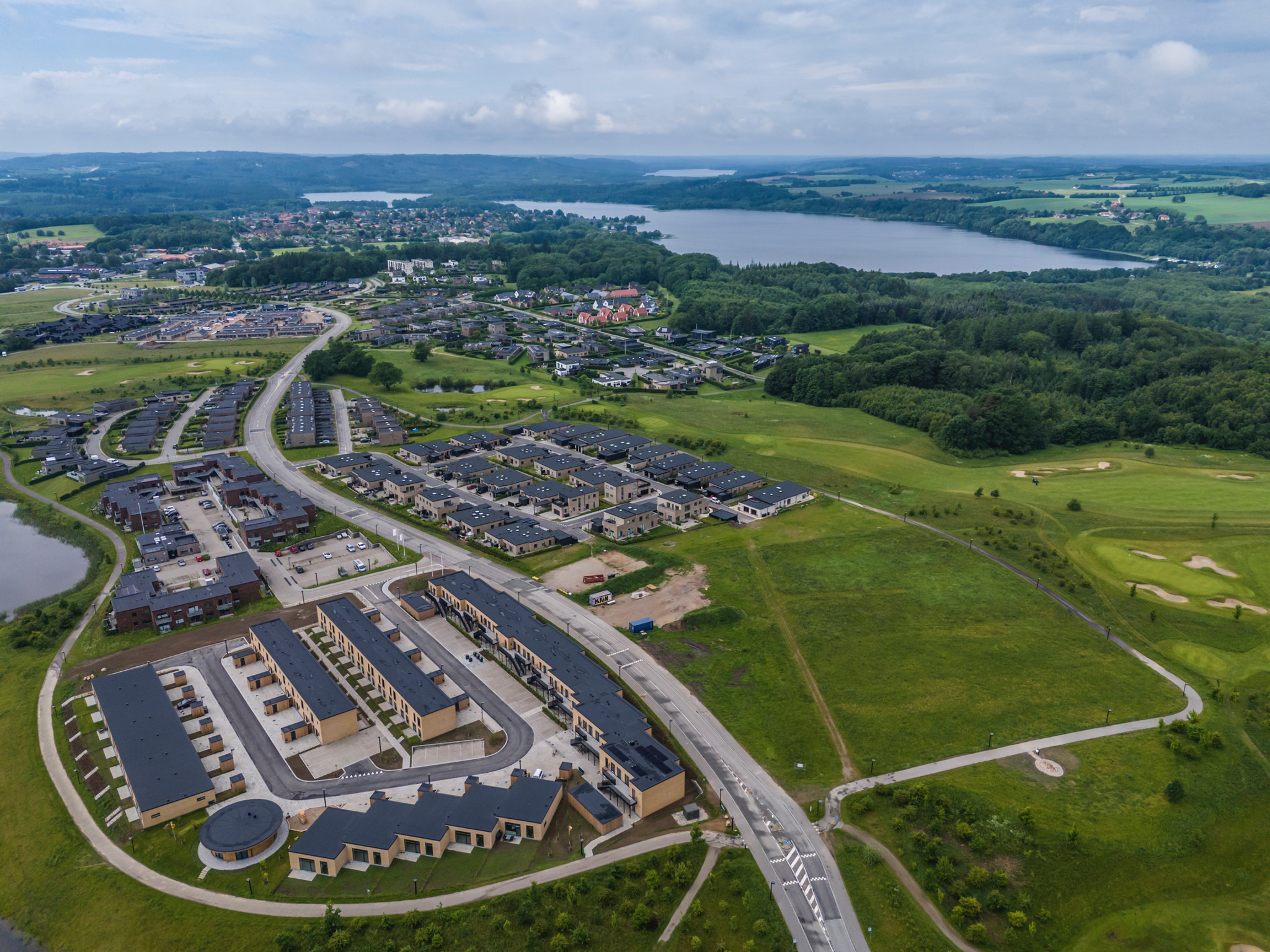 Luftfoto over by, boligområder og landskab i Østjylland